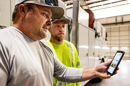 Two public works workers looking at an incident on a cell phone